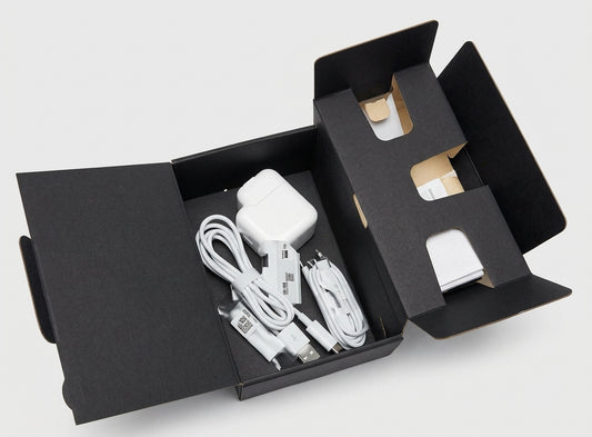 Black textured one-piece carton for handsets, size 2, opened out with a charger and cables inside